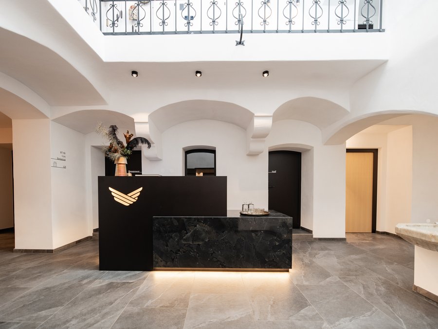 Moderner schwarzer Empfangstresen in einem weißen, hellen Hotelfoyer