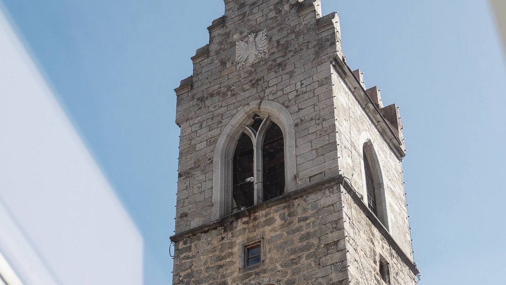 View of a historic clock tower through a skylight window under clear sky