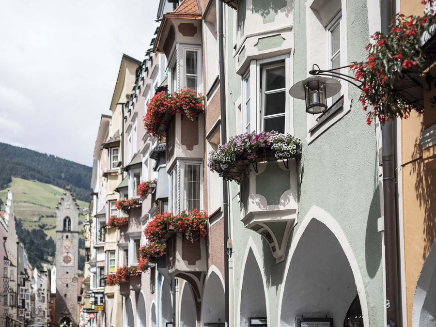 The laid-back town on the Isarco/Eisack river Colorful old houses with flowers in a scenic mountain village