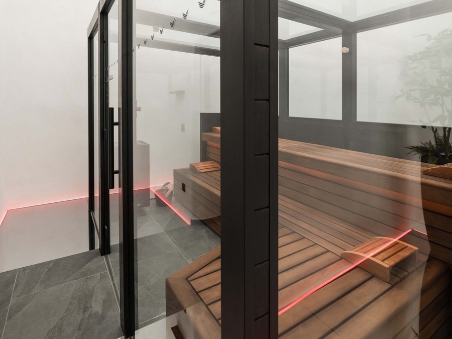 Benessere all’Aquila Nera Sauna moderna con pareti di vetro e panche di legno in ambiente minimalista