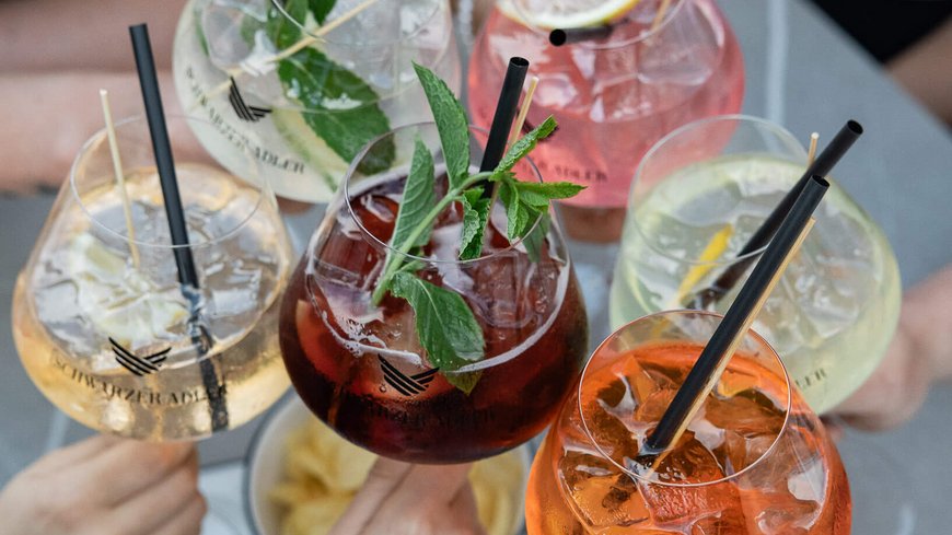 Die perfekte Location für euer Apartment in Sterzing Fünf verschiedene bunte Cocktails werden von Personen zum Anstoßen gehalten