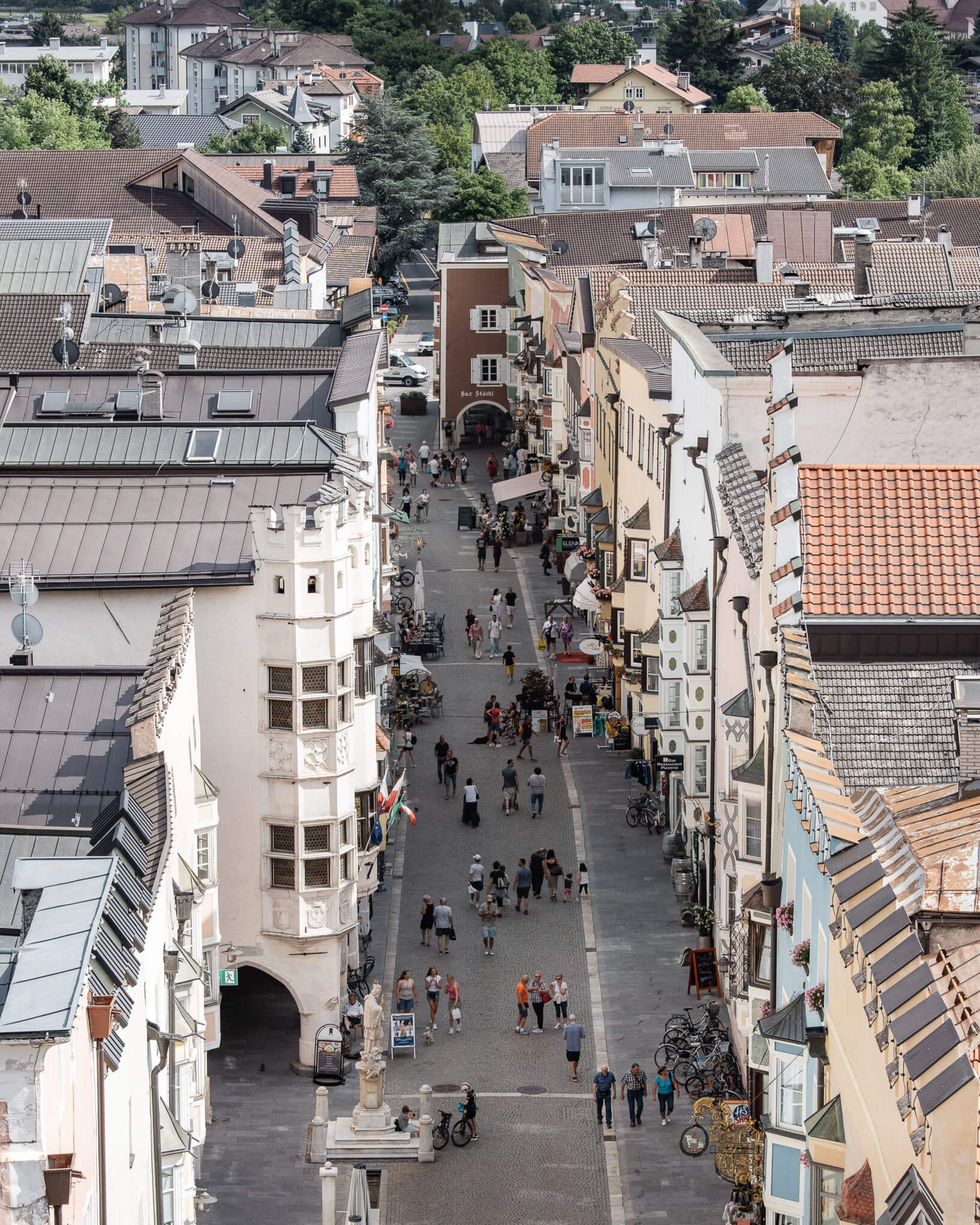 Blick auf eine belebte Fußgängerzone mit historischen Gebäuden