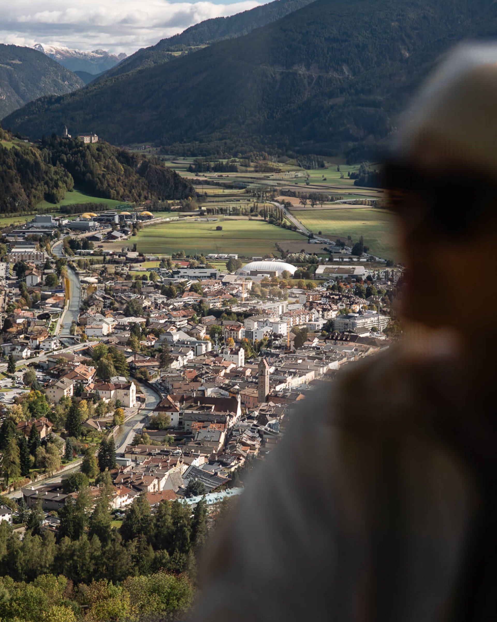 Bergstadt in Tal, unscharfe Person im Vordergrund