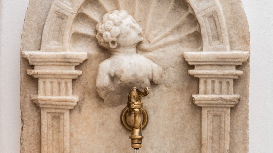 The laid-back town on the Isarco/Eisack river Antique water tap with marble cherub bust mounted on wall