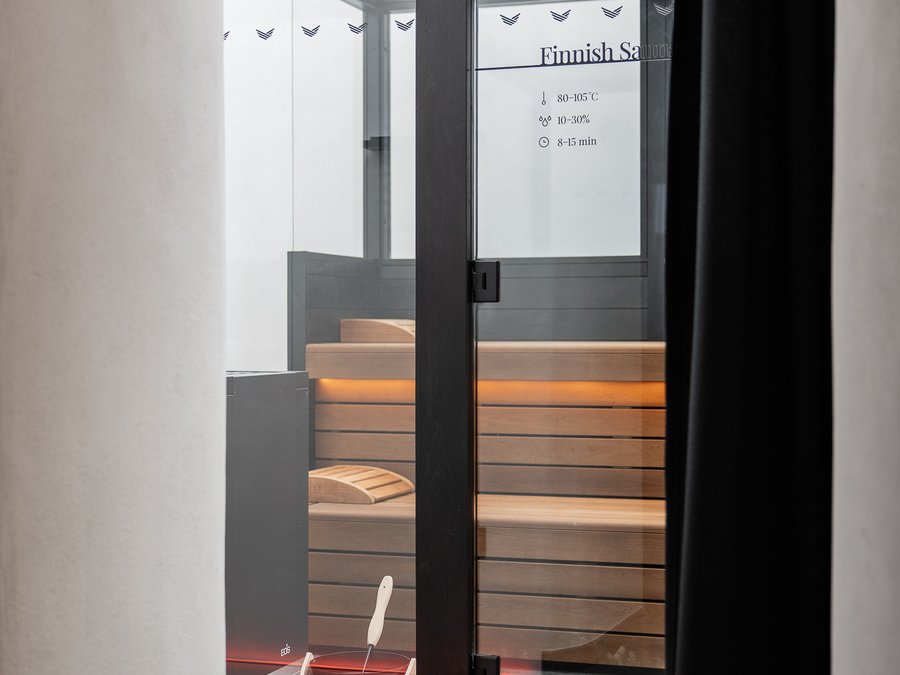 Die perfekte Location für euer Apartment in Sterzing Moderner finnischer Sauna-Raum mit Holzbänken und Eimer mit Schöpflöffel