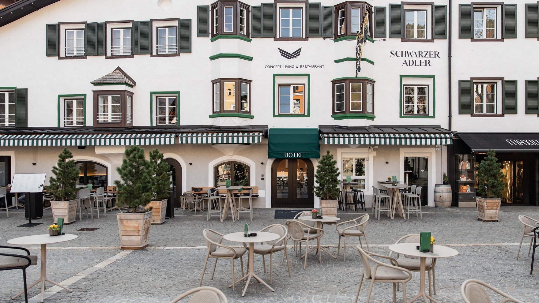 Die perfekte Location für euer Apartment in Sterzing Außenansicht des Hotels Schwarzer Adler mit Terrasse und leerem Sitzbereich