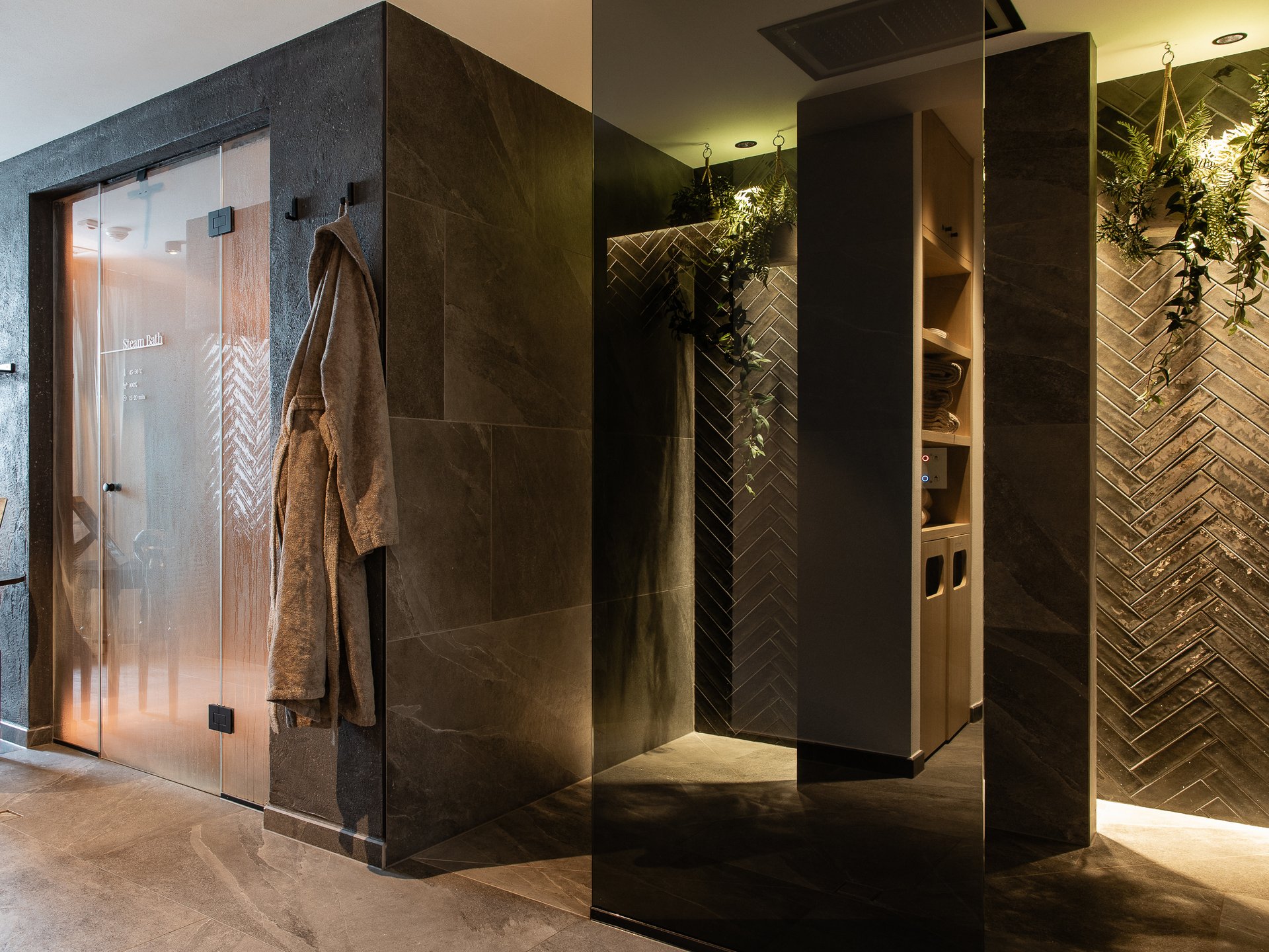 Modern spa area with steam bath and bathrobe hanging on the wall