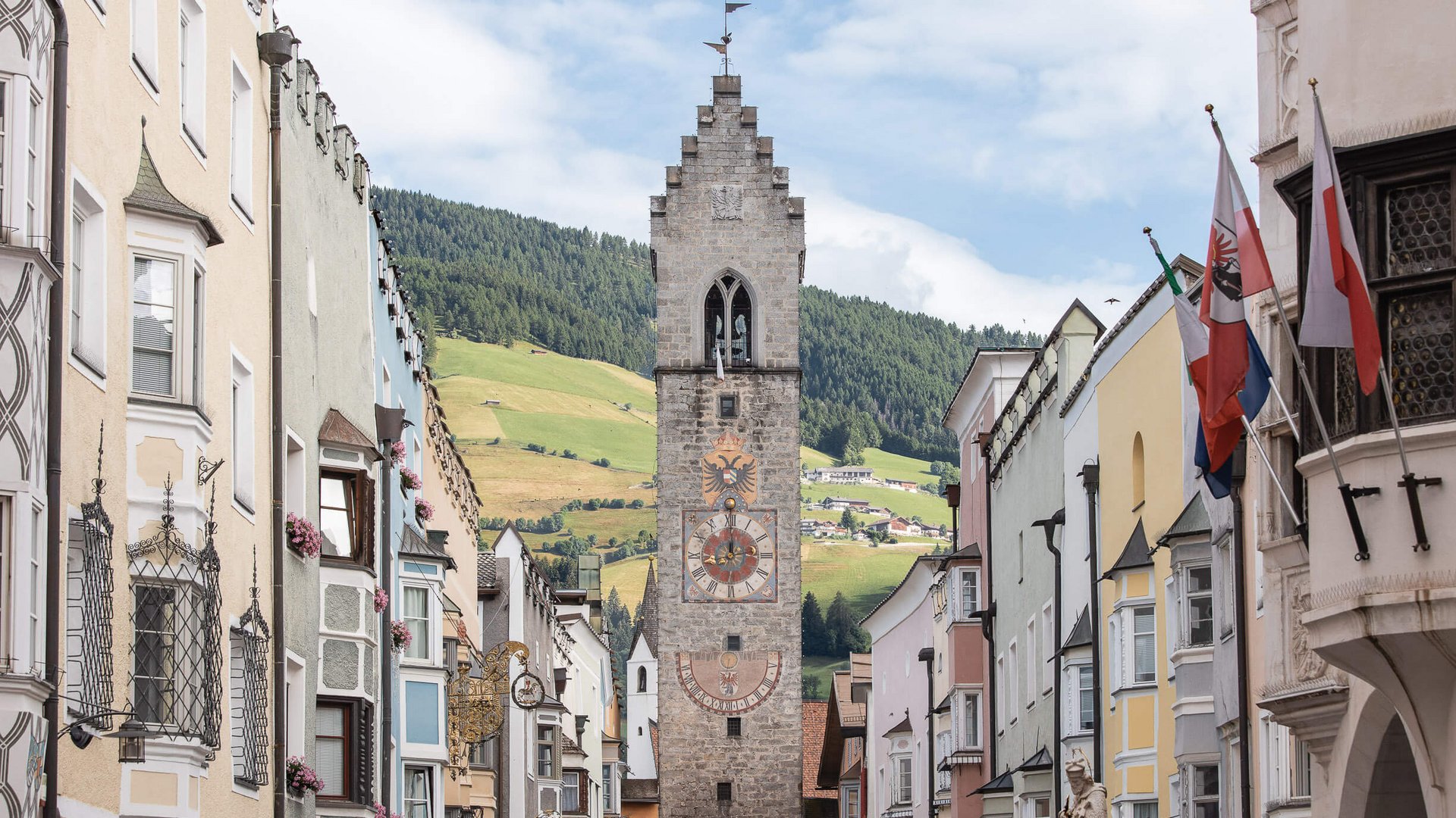 Blick auf den Zwölferturm in Sterzing mit Berglandschaft im Hintergrund