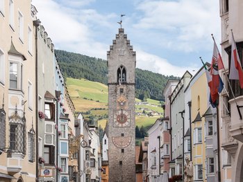 Blick auf den Zwölferturm in Sterzing mit Berglandschaft im Hintergrund
